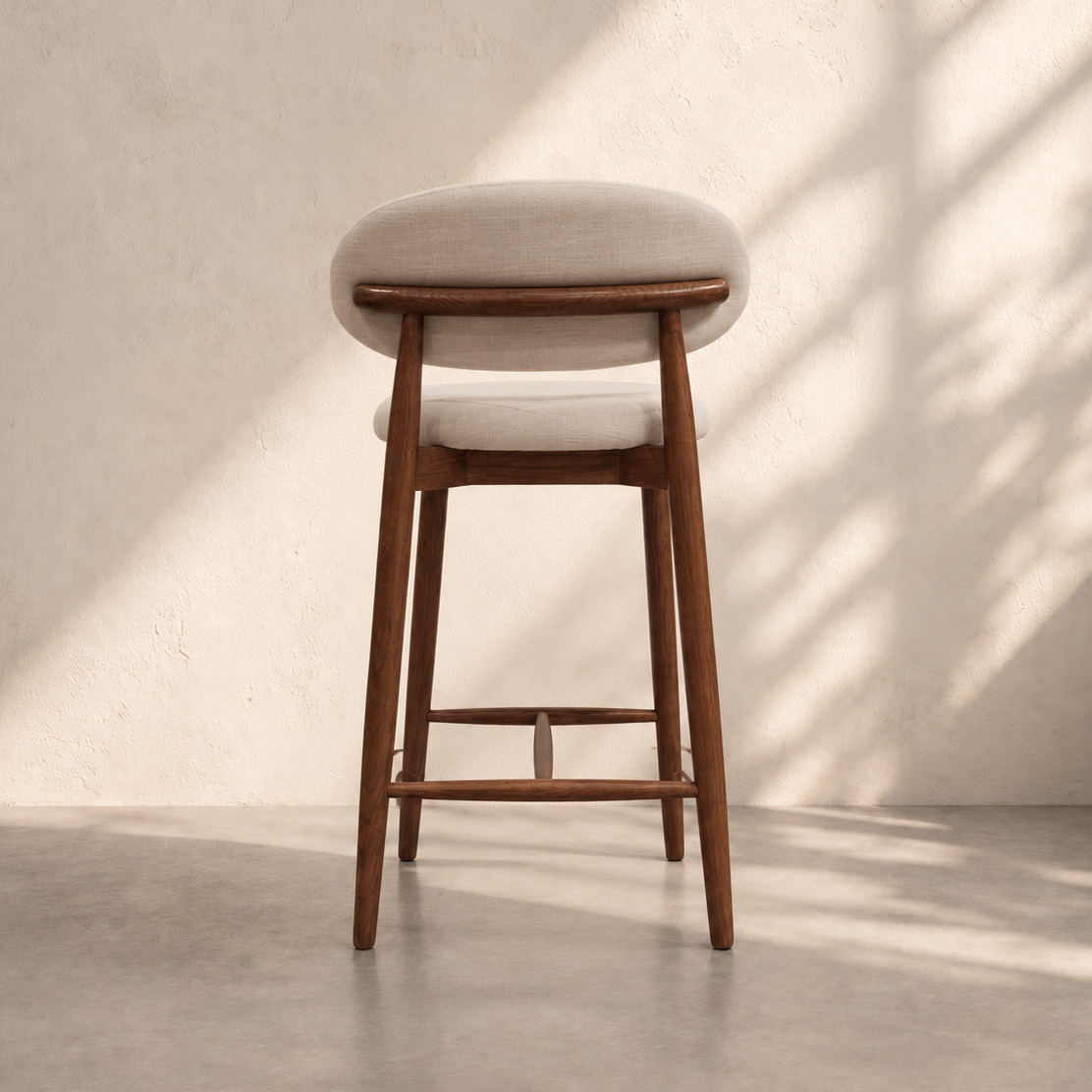 Havana Counter Stool with cream upholstered seat, curved backrest, dark brown wooden legs and footrest, ideal for modern kitchen islands in Dubai.