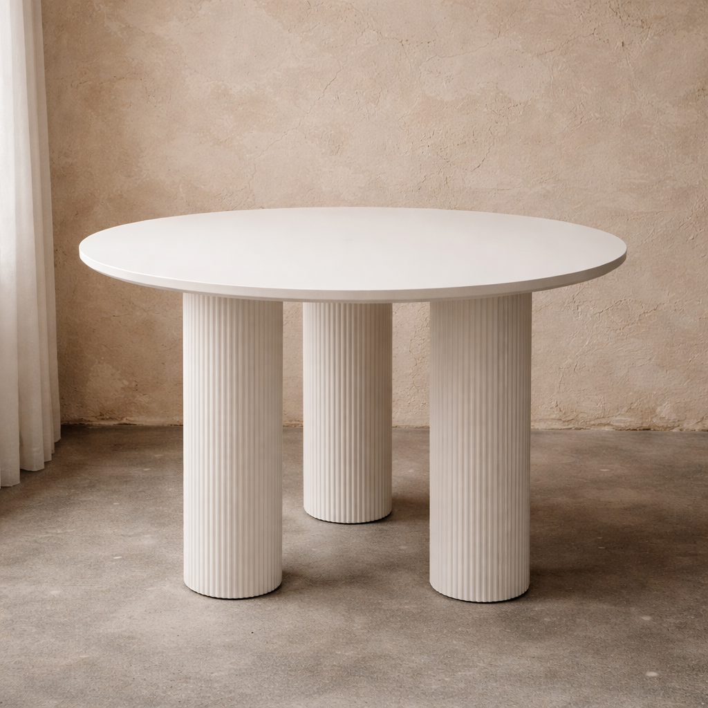 Sculptural round dining table with fluted pedestal legs and smooth white finish. Perfect for Japandi and modern dining spaces in Dubai & UAE.